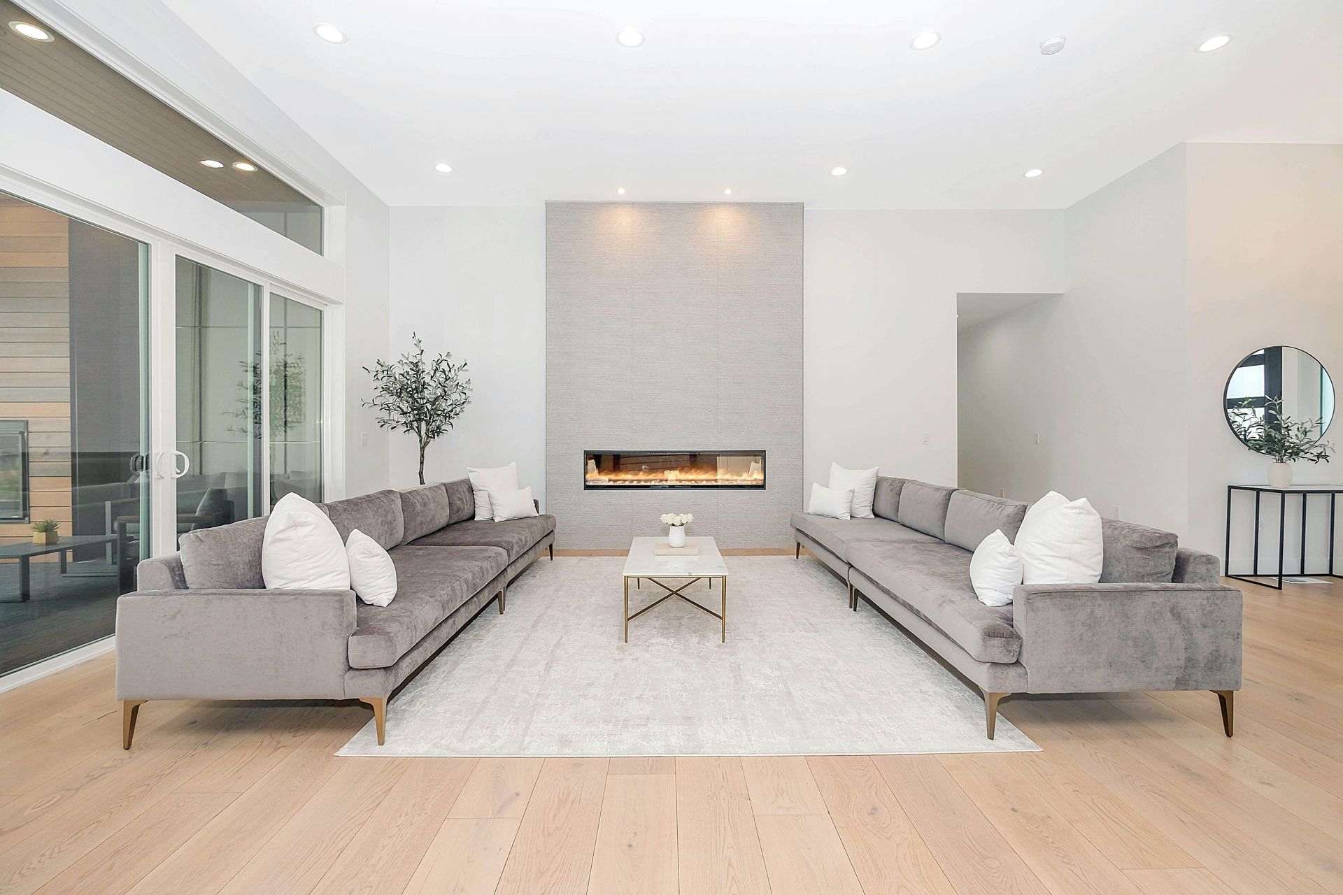Two grey velvet sofas facing each other in a bright modern living room